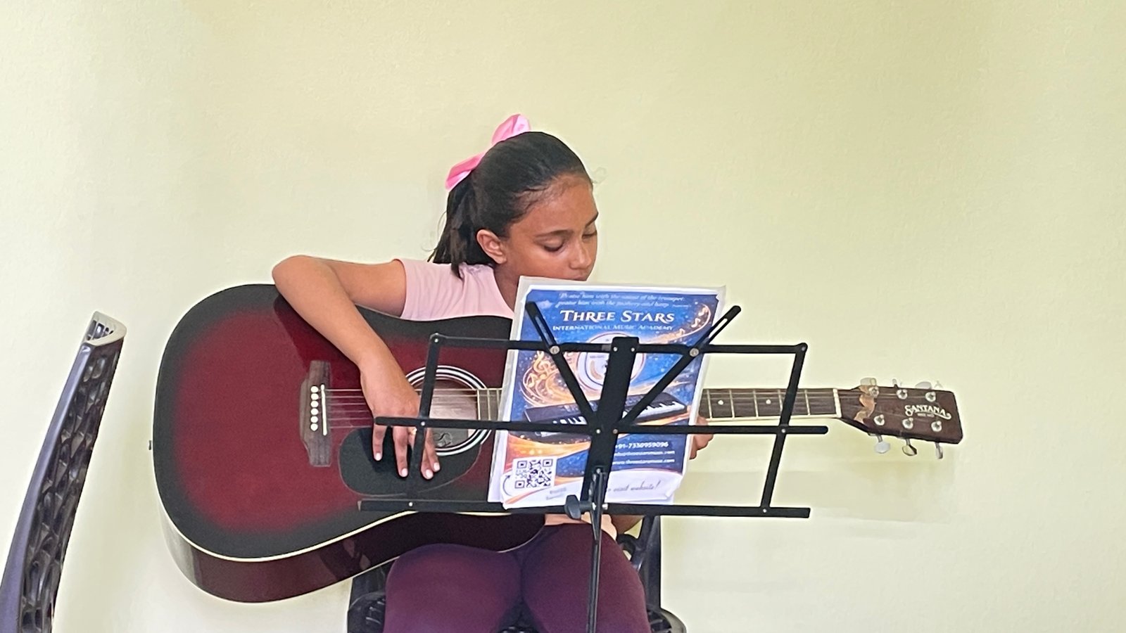 Student learning guitar at Three Stars International Music Academy