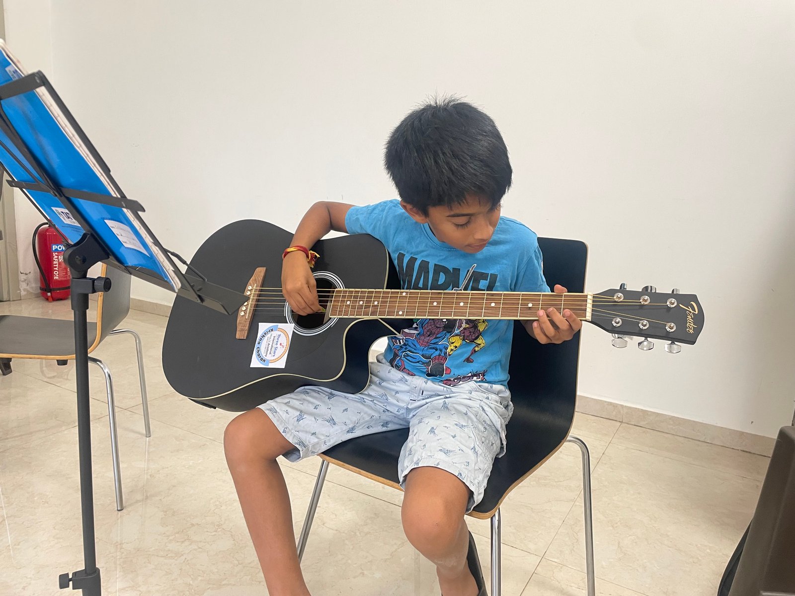 Student practicing guitar at Three Stars International Music Academy
